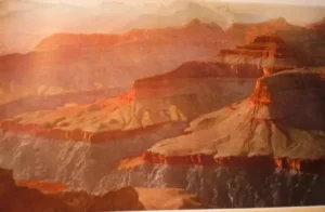 Scenic view of the Grand Canyon during sunset, showcasing layered rock formations and vibrant colors.