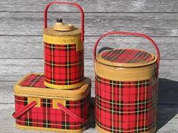 Three vintage picnic baskets with red tartan pattern, perfect for outdoor gatherings, displayed on a wooden surface.